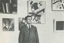 Malevich standing most probably in the Museum of Artistic Culture, Petrograd, 1924.