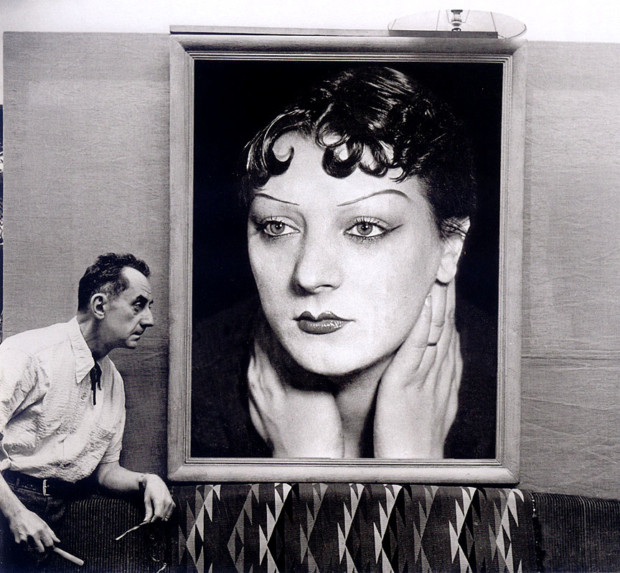 Man Ray in front of a portrait of Kiki de Montparnasse taken in the 1930s, Michel Sima.