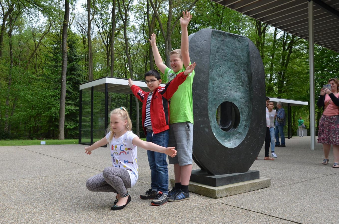 Children posing with Barbara Hepworth's Dual form, 1965 in the sculpture garden of the Kröller-Müller Museum.