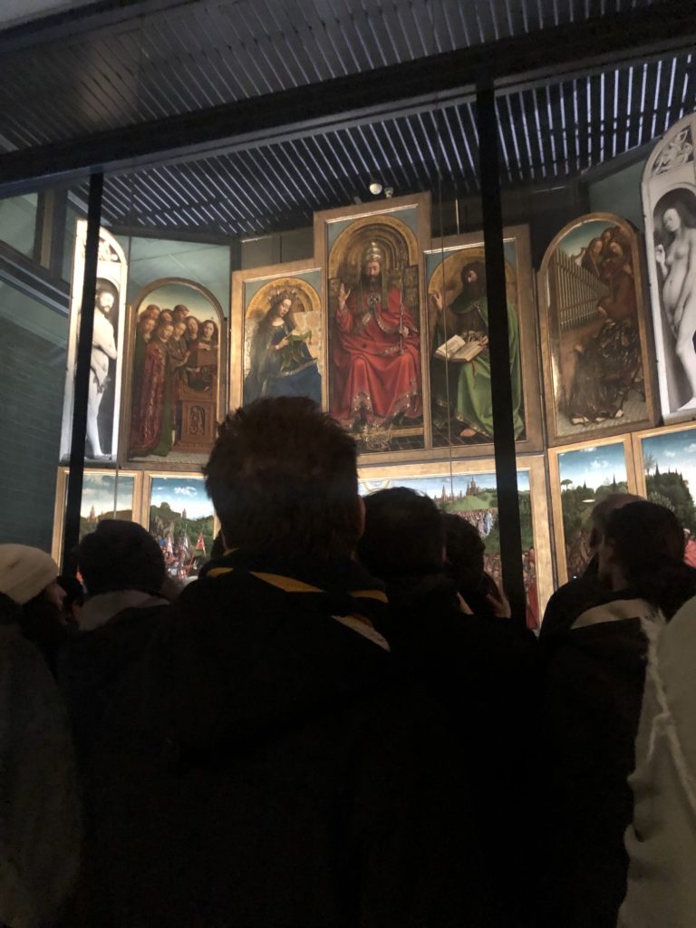 The very unfortunate conditions to watch The Ghent Altarpiece in the Saint Bavo Cathedral in Ghent. Photograph by Zuzanna Stanska van eyck exhibition van eyck an optical revolution