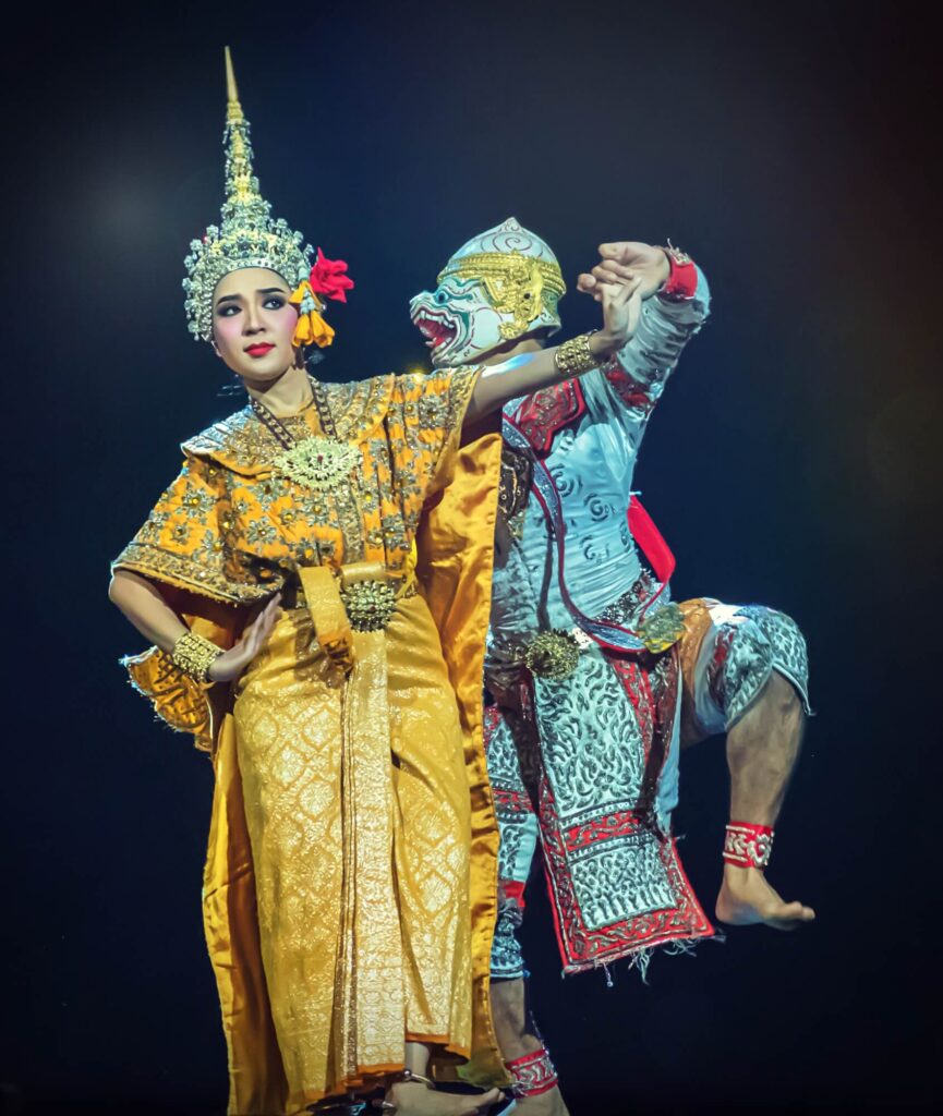 The scene from Khon (Thai masked dance drama) performance, the female dancer in the traditional costume is standing, the male dancer is holding her hand