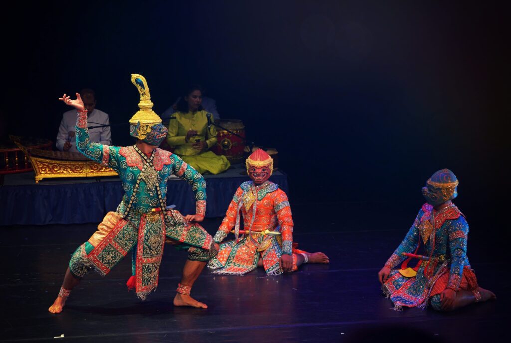 The Khon (Thai masked dance drama) performance, three men in the colorful costumes in the foreground with the orchestra in the background