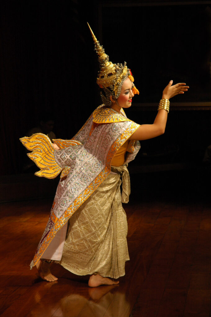 The Khon (Thai masked dance drama) female dancer in the traditional costume and headdress moves across the scene