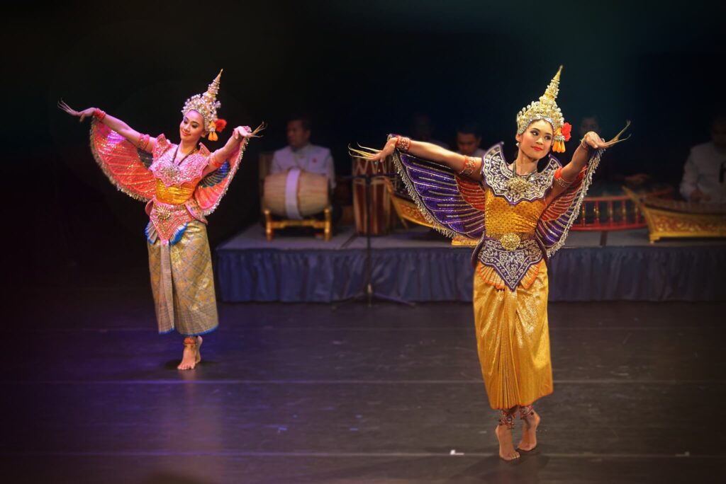 The Khon (Thai masked dance drama) with two female actresses dancing in the foreground and the orchestra is sitting in the background