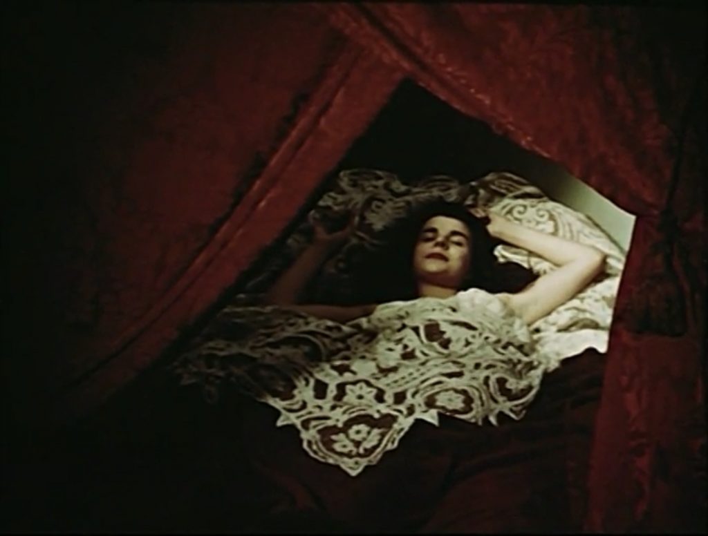 A woman in a white gown sleeping in a red-curtained bed, 
