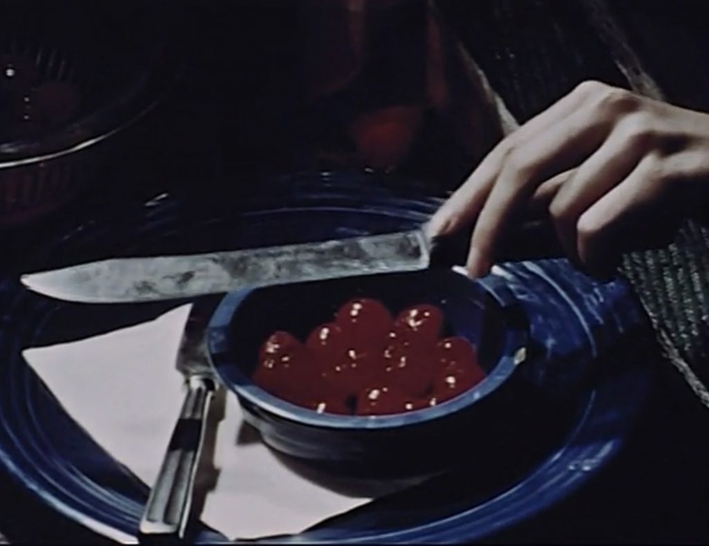 Still from Dreams That Money Can Buy, A woman reclined in a hammock offering Joe a bowl of cherries and a knife, Narcissus scene, 1947, directed by Hans Richter.