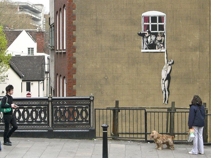 Banksy city guide 2021: Banksy, Well-Hung Lovers or Naked Man Hanging from Window, 2006