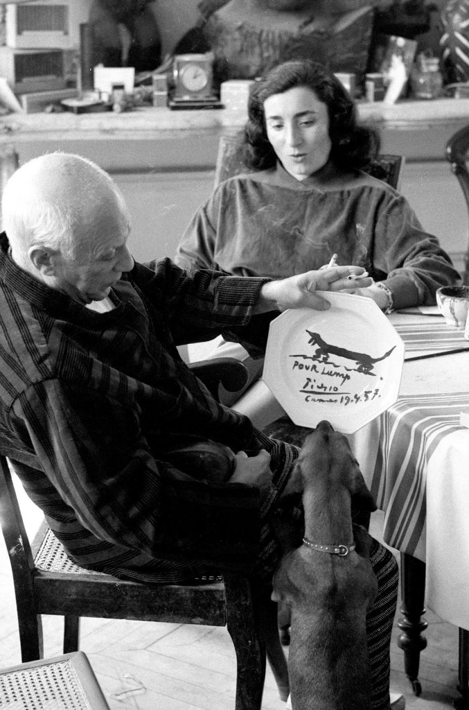 David Douglas Duncan, Pablo Picasso, presenting his dachshund Lump with a painted plate “For Lump” and Jacqueline Roque