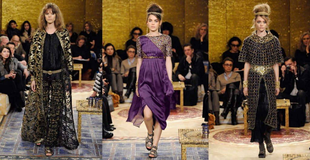 Three looks from Chanel fashion show inspired by Byzantine art: left: Black long dress with lace and long coat with golden embroideries; centre: purple dress with mosaic decoration. Black dress with golden embroideries and mosaic-inspired decoration. 