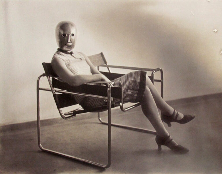 bauhaus turns 100: Erich Consemüller, A woman wearing an Oskar Schlemmer mask, seated in a Marcel Breuer Wassily Chair, c. 1926.

