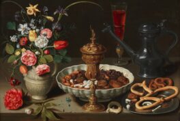 Vanitas painting with dark background. On the table are flowers, a scalloped dish filled with almonds, dates, and raisins, and pretzels on a pewter dish. There is also a pewter urn, a gold goblet, and wine glass filled with a red liquid.