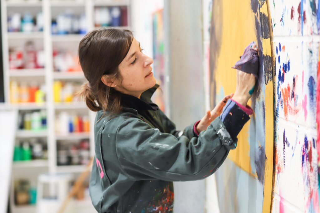 Photograph of Orlanda Broom painting in her studio.