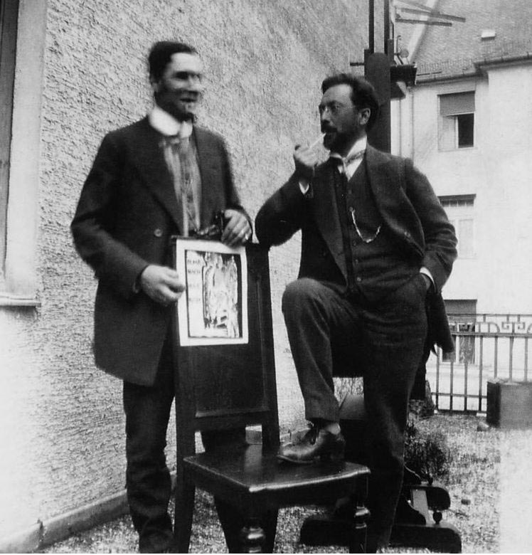 wassily Kandinsky abstract paintings: Franz Marc and Wassily Kandinsky with the cover design for Der Blaue Reiter, Munich, 1911. Photograph by Gabriele Münter via Wassilykandinsky.net.
