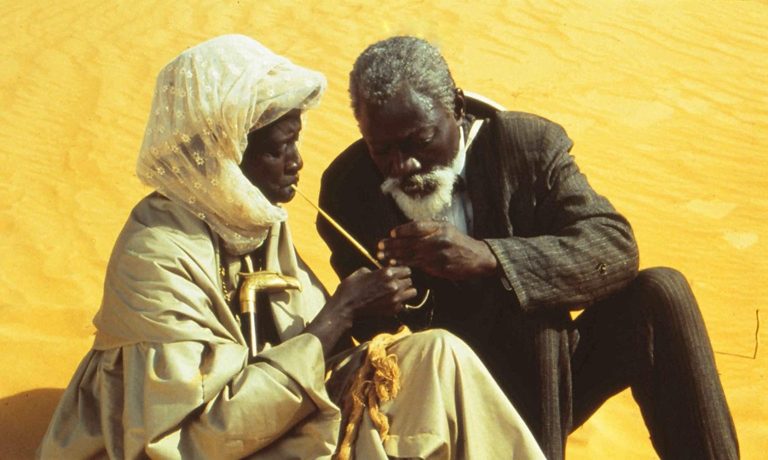 Djibril Diop Mambéty: Movie still from Hyènes, directed by Djibril Diop Mambéty, 1992. Independance Set Creation. Metrograph.
