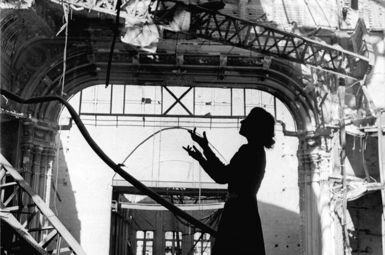 Lee Miller photographer: Lee Miller, Opera singer Irmgard Seefried singing an aria from Madama Butterfly in the ruined Vienna Opera House, 1945. Lee Miller Archive/The New York Times. Detail.

