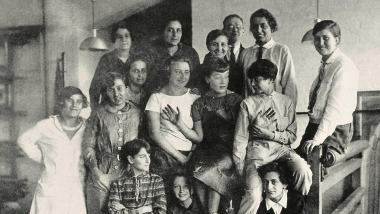 women of bauhaus: The weaving class in Bauhaus Dessau, Gunta Stölzl wearing a tie standing next to a painter Josef Albers, ca. 1927. Picture Alliance/AKG Images. Deutschland Funk.
