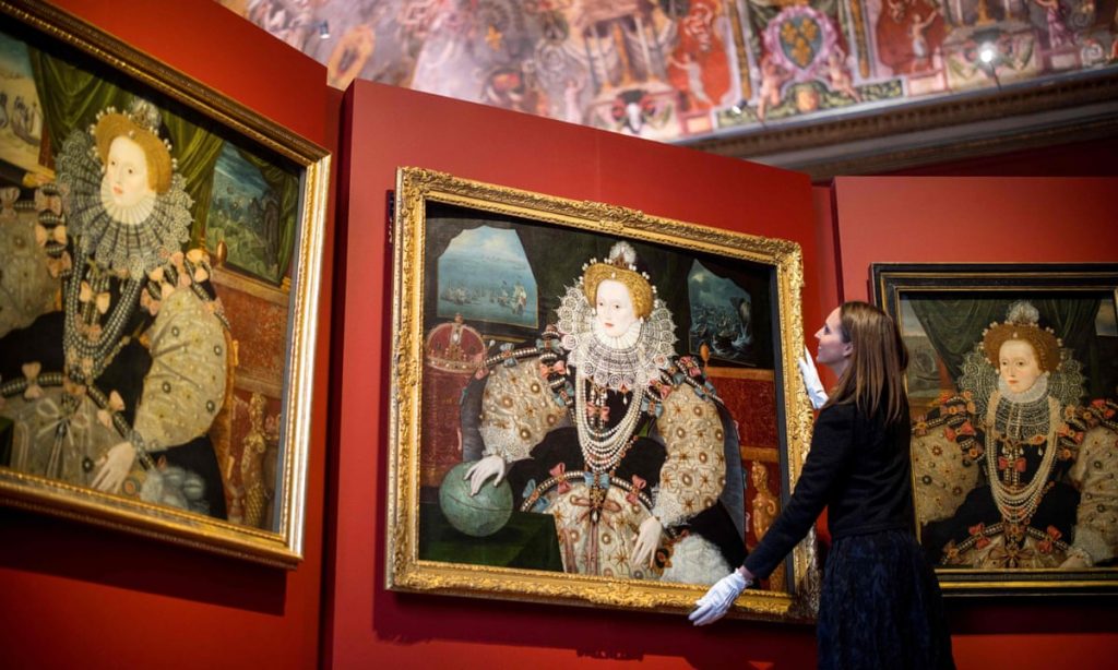 Royal Portraits: Royal Museums Greenwich curator Allison Goudie adjusts one of the Armada portraits before the opening of the Faces of a Queen exhibition. Photograph: Tolga Akmen/AFP via Getty Images. The Guardian.
