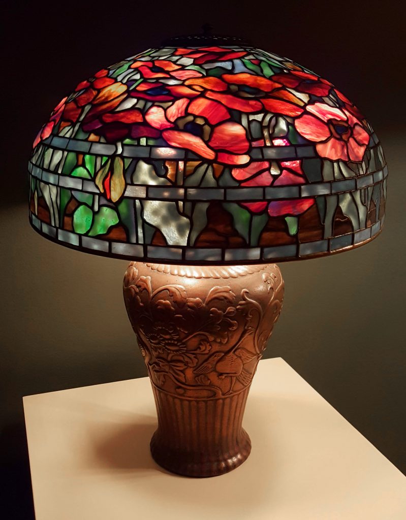 Red floral Tiffany's lamp over a thick base.