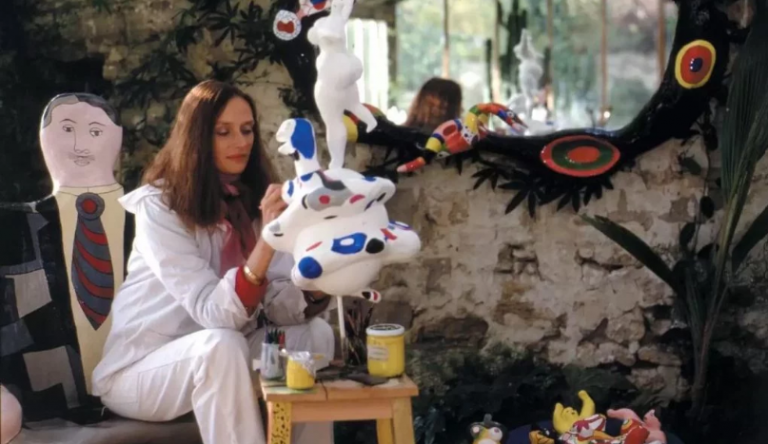 Niki de Saint Phalle paradis: Niki de Saint Phalle surrounded by her sculptures painting Le Monde, c. 1981. Photograph by Laurent Codominas © 2010 Niki Charitable Art Foundation, all rights reserved. Courtesy of Opera Gallery. Detail.
