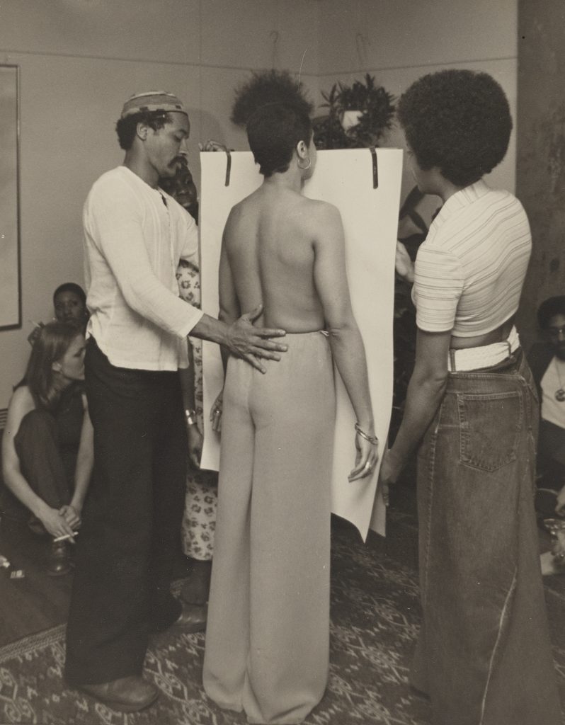 David Hammons (left) and Suzette Wright (center) at the Body Print-In held in conjunction with Hammons’s exhibition Greasy Bags and Barbeque Bones, Philip Yenawine’s home, 1975. Photograph by Jeff Morgan. Courtesy David Hammons. Collection Linda Goode Bryant, New York