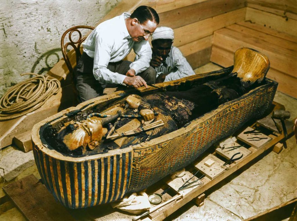Tutankhamun: Photograph of Howard Carter and a staff member examining the innermost sarcophagus of Tutankhamun, 1925, Luxor, Egypt, Griffith Institute, University of Oxford, Oxford, UK. Colorized by Dynamichrome.
