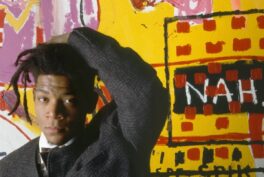 Jean-Michel Basquiat at an exhibition of his work in 1988, Vrej Baghoomian Gallery, New York, NY, USA. Photograph vt Julio Donoso via The Guardian.