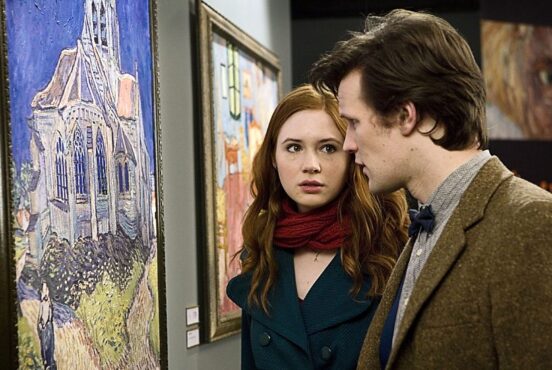 Screencap from Doctor Who episode. From left hand side of image: Vincent van Gogh’s The Church at Auvers is on the wall, side on to the viewer. The church windows are at eye level. The Doctor studies the painting intently. Companion Amy looks to the Doctor with a troubled expression.