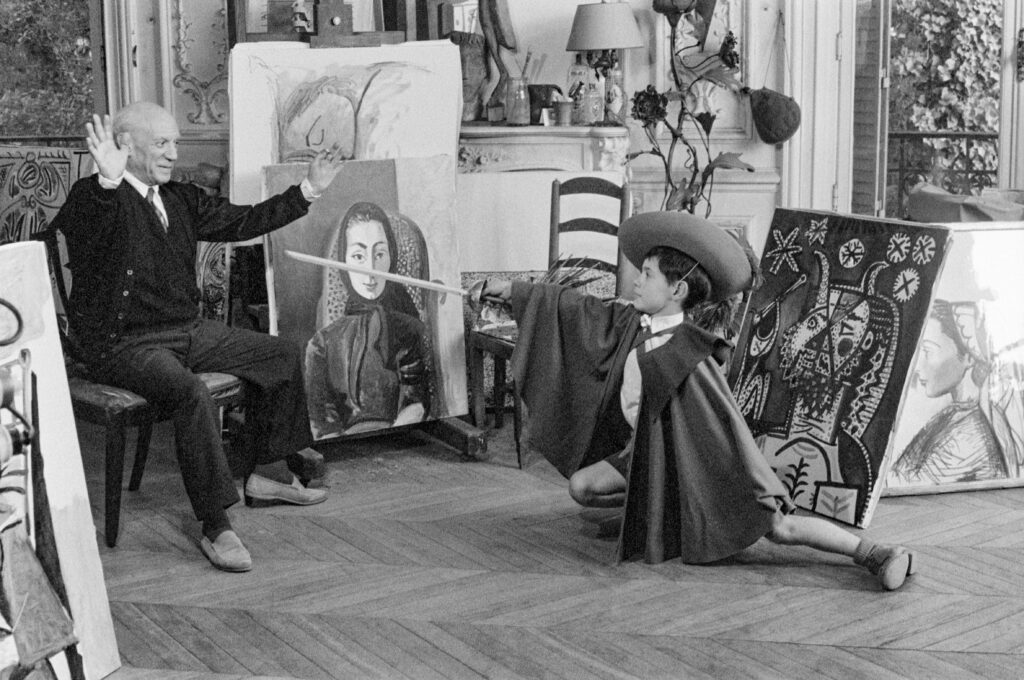 Claude Picasso: Pablo Picasso with his son Claude in a musketeer outfit, La Californie, Cannes, 1955. Photograph by Edward Quinn. © Edward Quinn Archive.
