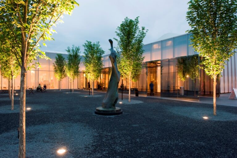north carolina museum of art staff picks: Exterior of West Building entrance and courtyard garden at night, North Carolina Museum of Art, Raleigh, NC, USA. Wikimedia Commons (public domain).
