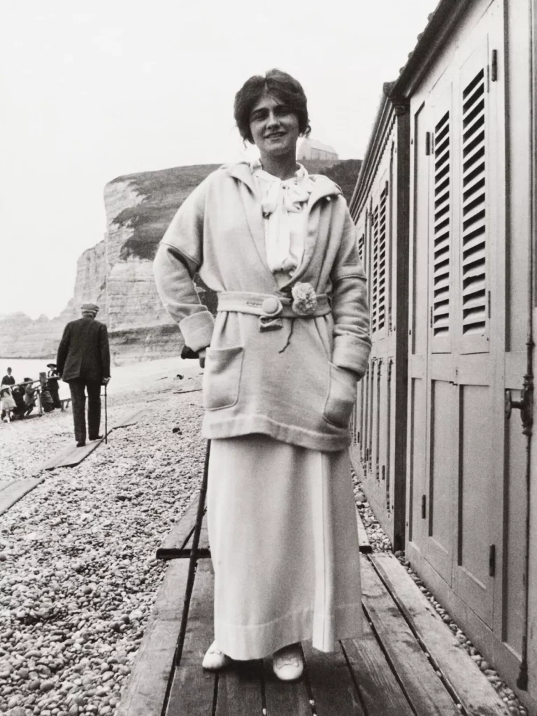 coco chanel designs: Gabrielle “Coco” Chanel wearing a camellia pin on the beach at Étretat, France, ca. 1913. Vogue Scandinavia.
