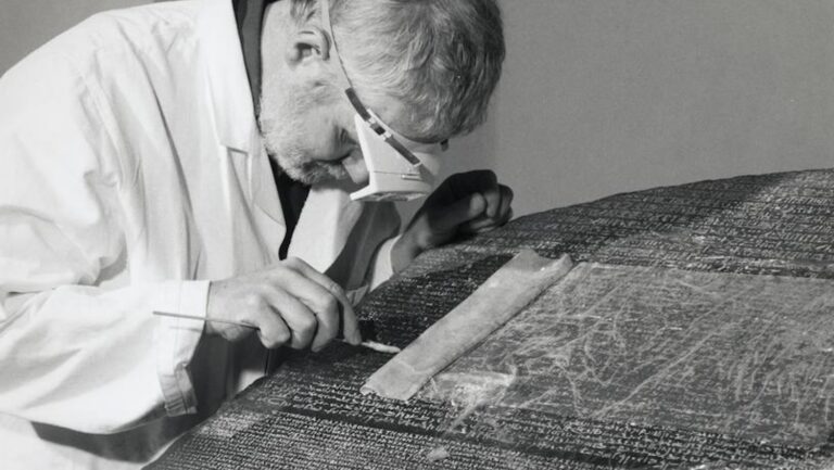 Rosetta Stone history: British Museum conservator cleaning the inscription on the Rosetta Stone. British Musuem. Detail.
