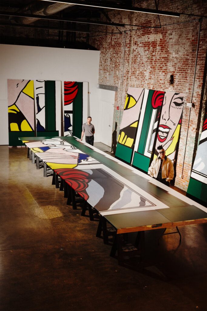 Roy Lichtenstein Like New: Curator Meg Onli (right) with artist Alex Da Corte (left) in his North Philadelphia studio, with the painted plywood panels for the recreation of Lichtenstein’s Girl in Window (1963), originally made for the 1964–1965 World’s Fair. David Billet/The New York Times.
